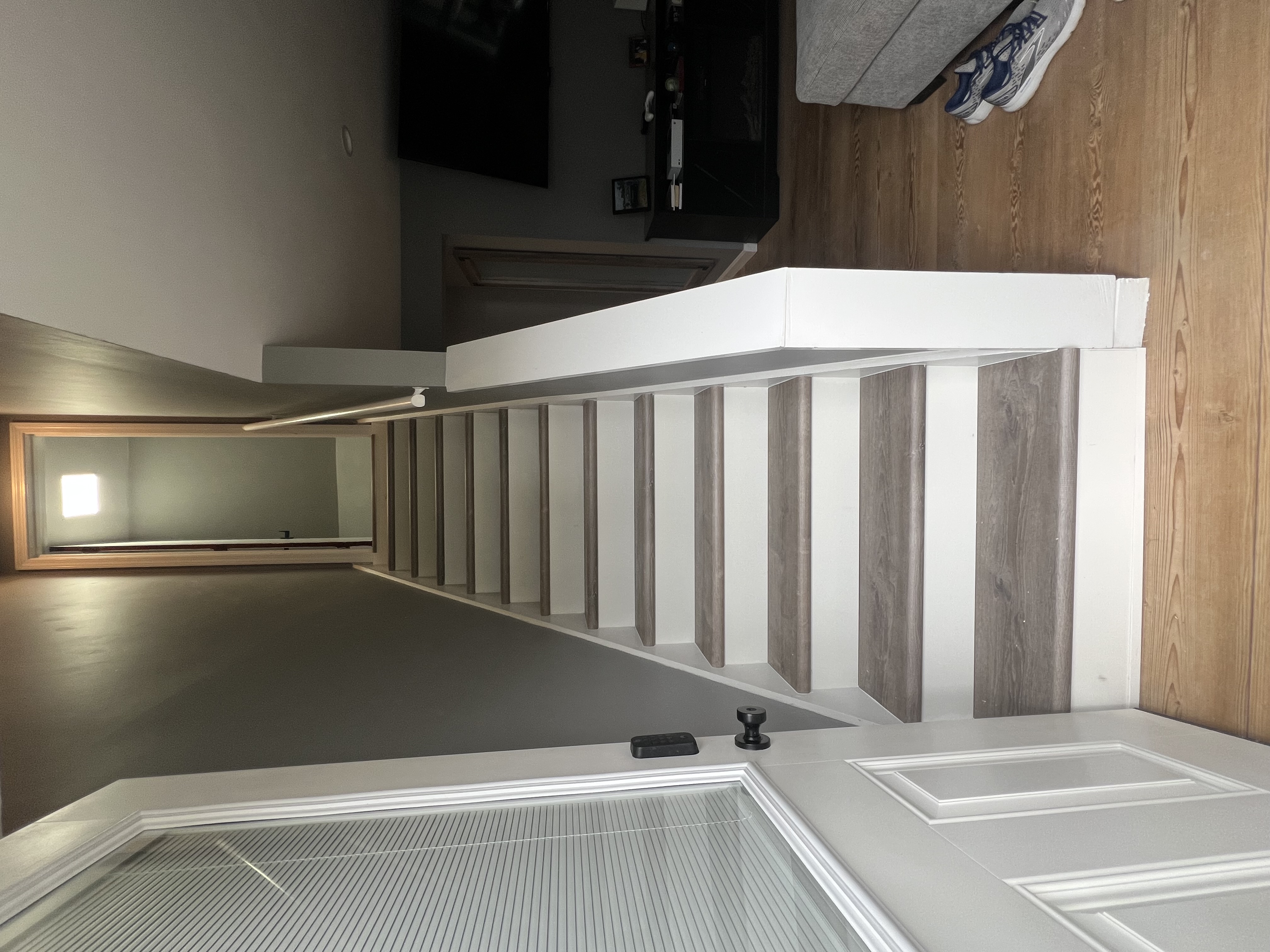 Finished stairway with gray walls, white risers, and wood treads.