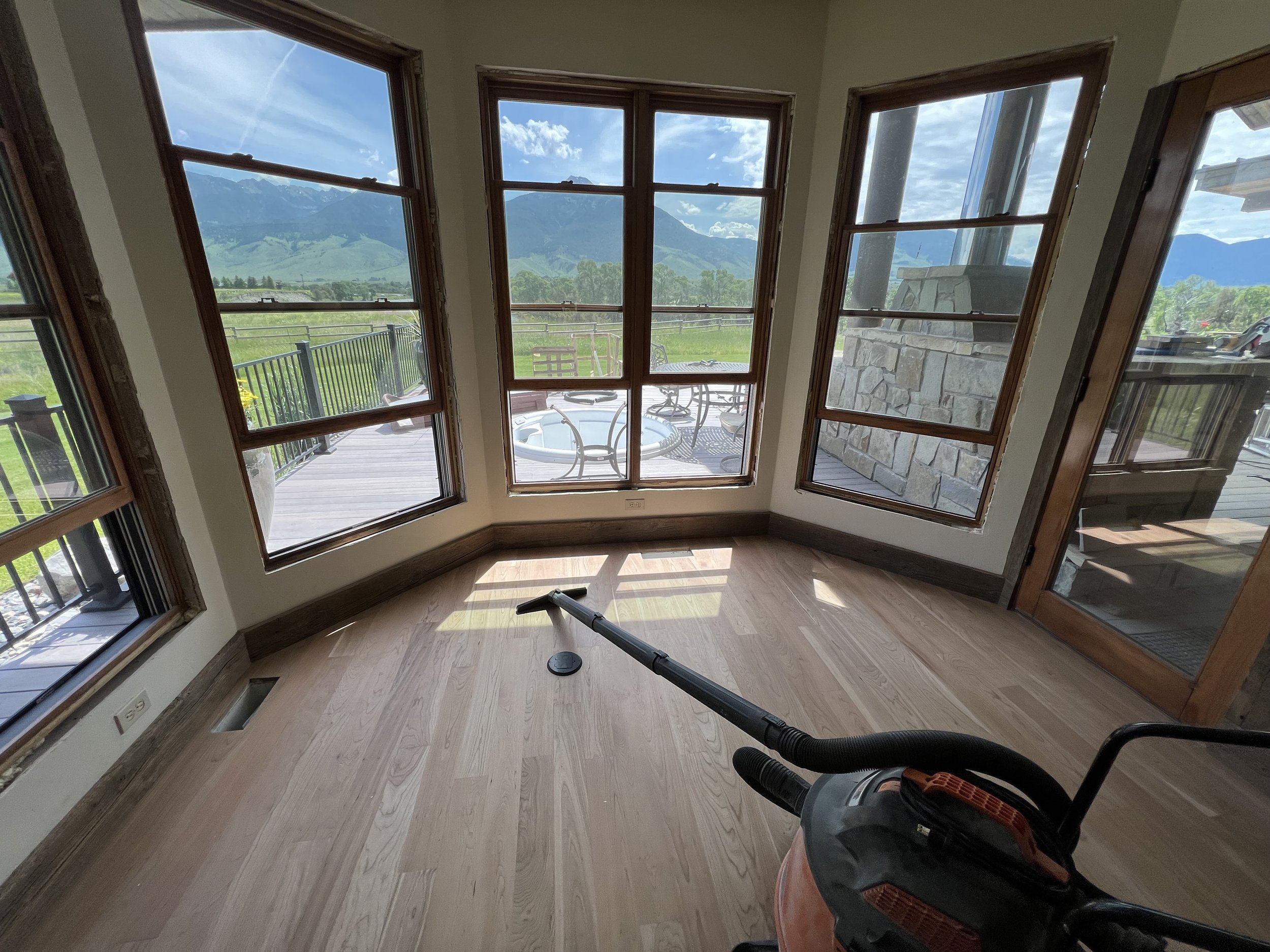 Finished wood flooring and trim around large windows with mountain views.