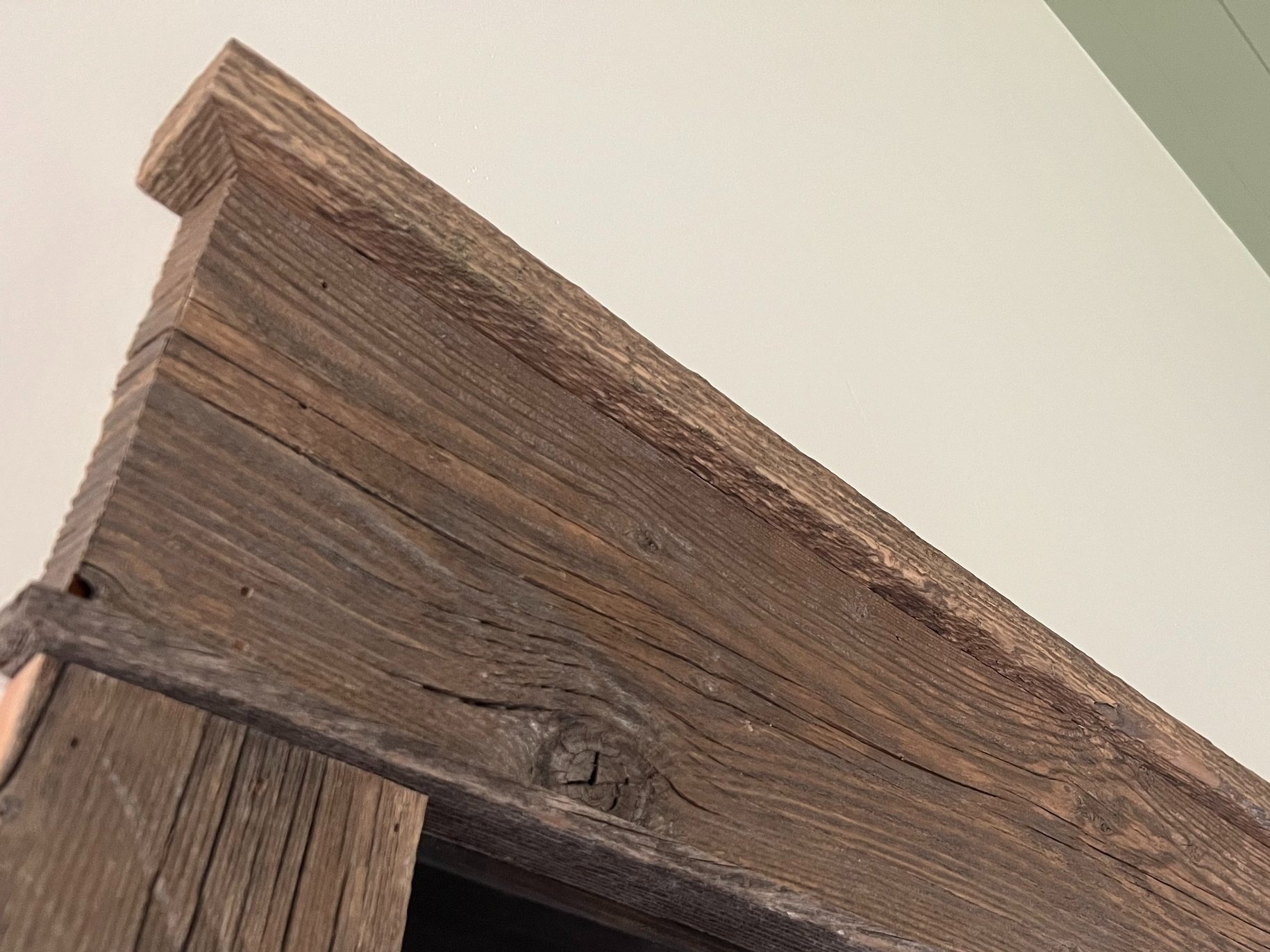 Close-up of rustic wood trim detail above a doorway.